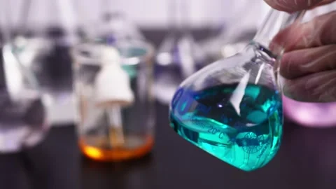Laboratory test tubes with samples Scientists hold a beaker with a blue liquid i Stock Footage 169437705
