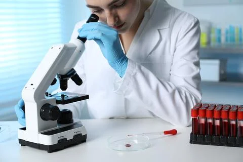 Laboratory testing. Doctor working with microscope at table indoors Stock Photos
