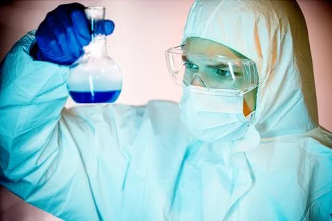 Laboratory worker analysing flask with blue liquid. Man doing science tests Foto stock
