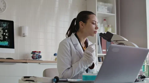 Laboratory Worker Examining Samples in Microscope when Conducting Research Stock Footage 332358470