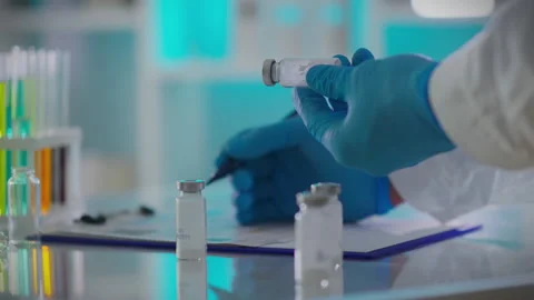 A laboratory worker in glasses carefully performs laboratory research in a m Stock Footage 263654450