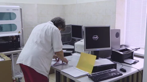 Laboratory worker managing diagnostic data near in a clinic. Stock Footage 329998369