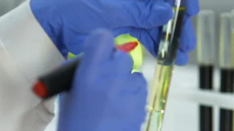 Laboratory worker marking test tube with refined oil sample fuel quality control Stock Footage 104565689