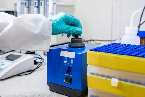 Laboratory worker mixes samples with a vortex mixer in preparation for HPLC Stock Photos