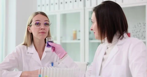 Laboratory worker offers colleague to test aroma of liquid Stock Footage 279723732