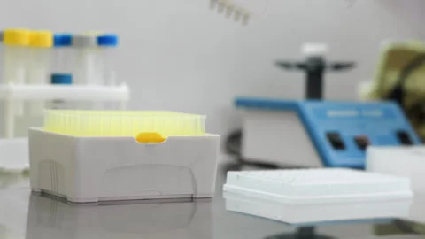 Laboratory worker opening a pipette box and putting the tips on the pipette. 스톡 동영상 294158367