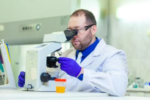 Laboratory worker performing urinalysis using microscope and laboratory Stock Photos