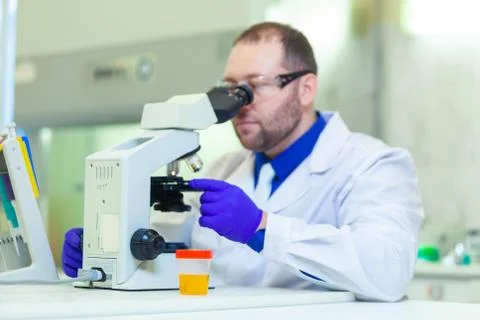 Laboratory worker performing urinalysis using microscope and laboratory Stock Photos