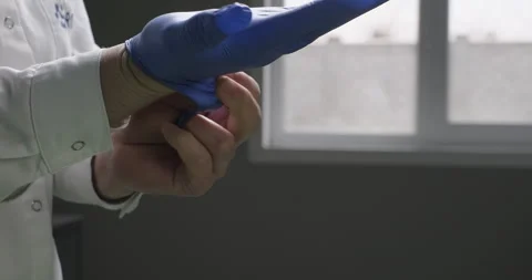 Laboratory worker wearing blue hand gloves at health clinic or hospital. Medical Stock Footage 273107213