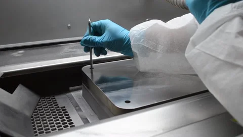 Laboratory worker in white protective suit and gloves installing metal platform Stock Footage 232819699