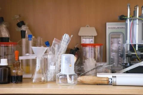 Laboratory workspace filled with various glassware, beakers, and scientific Stock Photos
