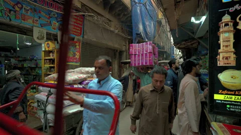 Laborer carrying a massive stack of boxes on his head in Old Delhi Stock Footage 340270663