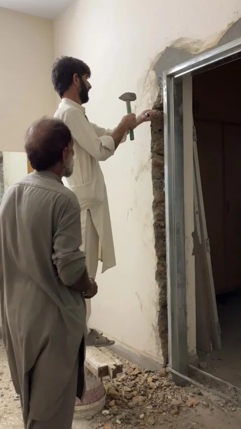 A laborer is hammering on a wall. Stock Footage 340235291