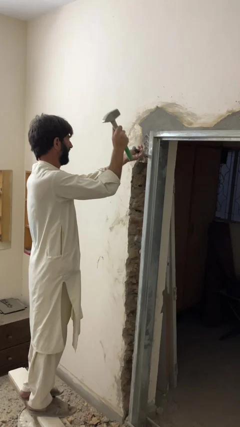 A laborer is hammering on a wall. Stock Footage 340235305