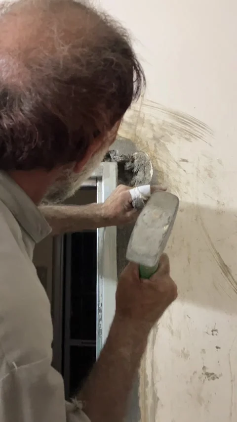 A laborer is hammering on a wall. Stock Footage 340235306