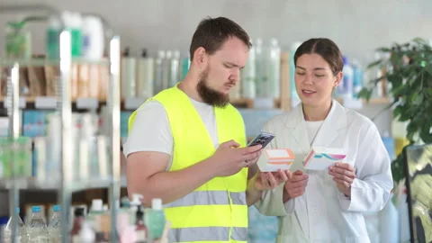 Laborer man builder in pharmacy scans QR code on pills box, pharmacist offer Stock Footage 308957632