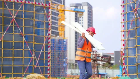 Laborer man construction worker wearing protective gear red hard hat, orange Stock Footage 346052696