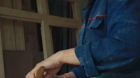Laborer is using the small scraper instrument to put the material on the window Stock Footage 164912392