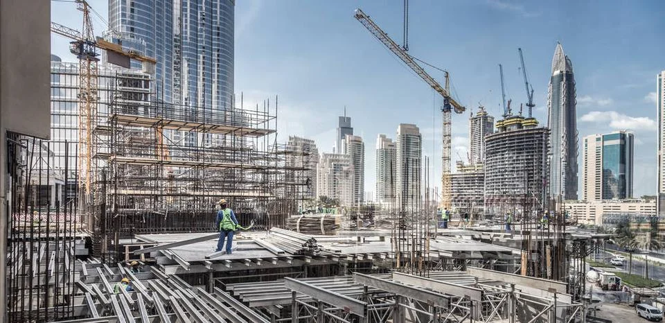 Laborers working on modern constraction site works in Dubai. Fast urban de... Stock Photos