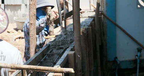 Labour group working on cement wall and ground beam building Stock Footage 164587518
