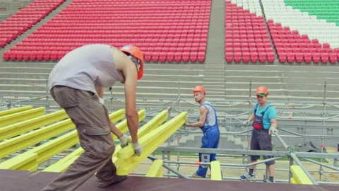 Labourer gives timber to colleague at construction site Stock Footage 238933415