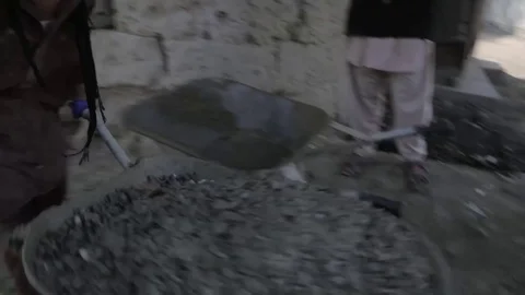 Labourer pushing wheelbarrow of cement on construction site in Kabul Afghanistan Stock Footage 91970064