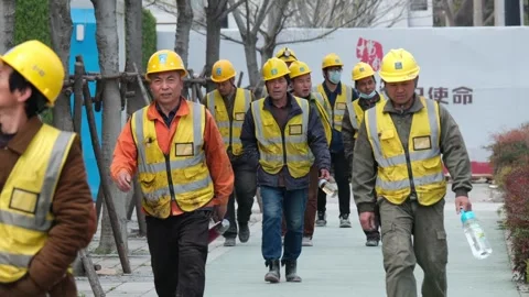 Labourers walking towards a construction site in Shanghai Stock Footage 270195001