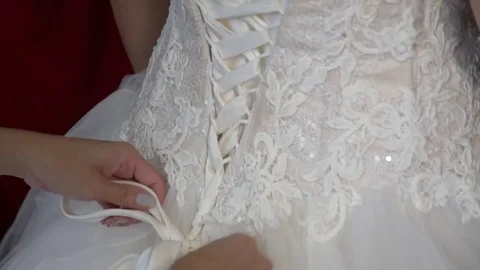 Lace back. Bridesmaid helping bride with wedding dress. Stock Footage