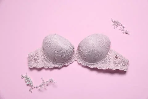 Lace bra and decorative elements on pink background, flat lay Stock Photos
