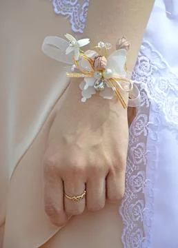 Lace garter with multi-colored artificial flowers on the wrist of the bridesmaid Stock Photos