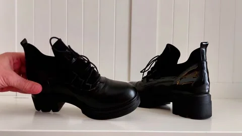 Laced Up and Elevated- Black Platform Shoes on White Surface Vídeos de archivo 321518288