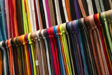 Laces samples hang on rack in light hallway at exhibition Stock Photos