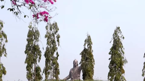 Lachit Borphukan statue partially visible behind trees in Dibrugarh Stock Footage 332612910