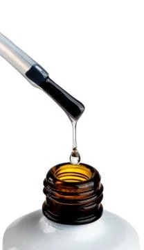 Lacquer drop at the tip of the brush. vicious liquid drop and white glass bottle Stock Photos