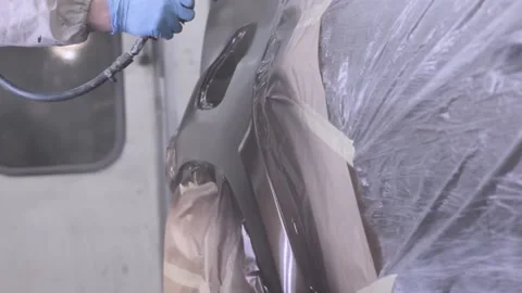 Lacquer spraying on the rear part of a covered car in paintbox Stock Footage 130576520