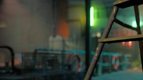 Ladder in a construction site with neon lights in the background at night Stock Footage 344851493