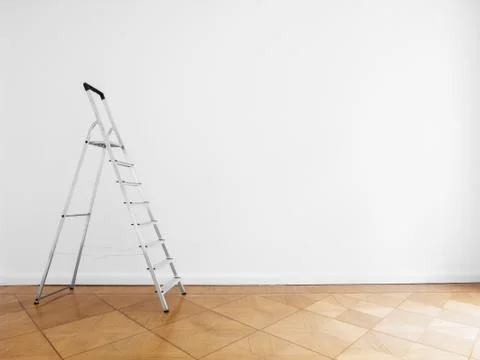 Ladder in empty room with white wall and wooden floor Stock Photos