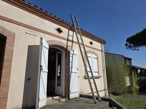 Ladder leans on building as work goes on Stock Photos