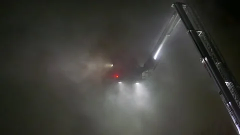 Ladder with platform in heavy smoke at night with firefighters 動画素材 139657065