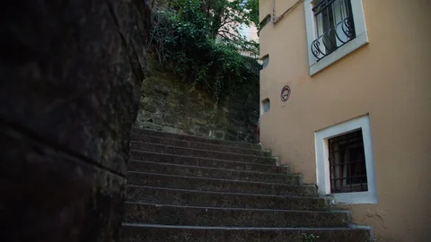 Ladies climb down stone steps walking along narrow street Stock Footage 116722565