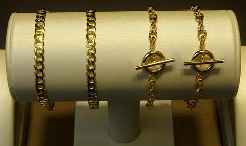 Ladies Gold Solid Curb Link And T Bar Bracelets Stock Photos