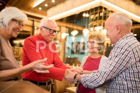 Ladies introducing their husbands to each other Stock Photos