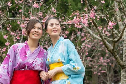 Ladies stand in front the cherry tree and laugh Stockfoto's