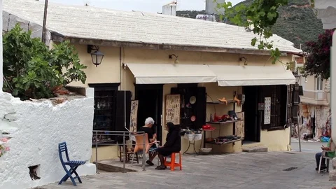 Ladies work on lacework outside typically Greek shop Stock Footage 85877547