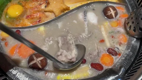 Ladle Scooping Meat from a Divided Hot Pot Видео 346737894