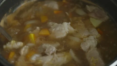 Ladle scooping savory soup with meat and vegetables from pot Stock Footage 335392051