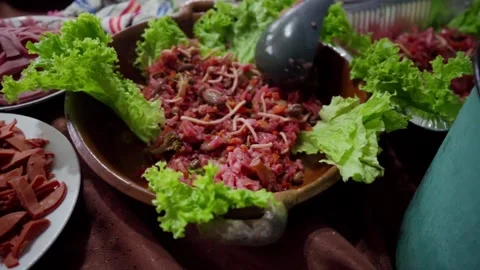 Ladle serving red curtido over clay plate with lettuce in Guatemalan fiambre pre Stock Footage 318378952