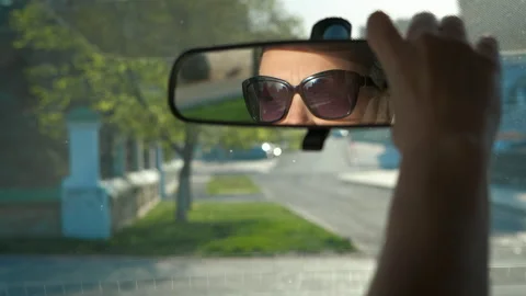 Lady adjusts mirror in car. Stock Footage 304752319