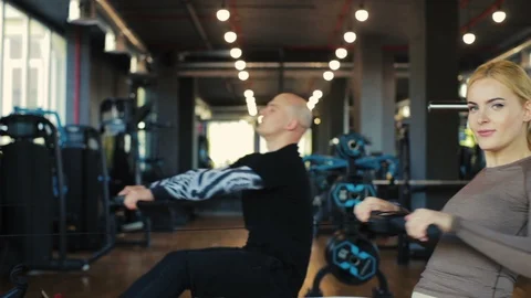Lady and man do straight back seated cable rows slow motion Video stock 111283248