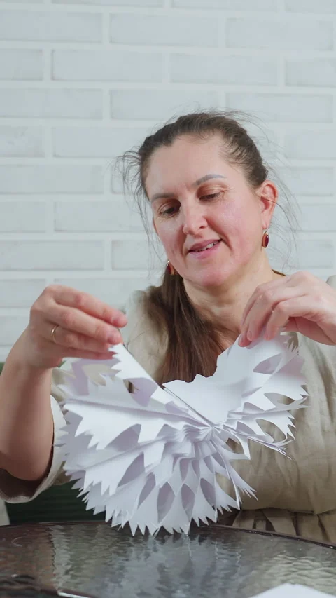 Lady assembling paper snowflake during holiday activity, Female preparing Stock Footage 326824283
